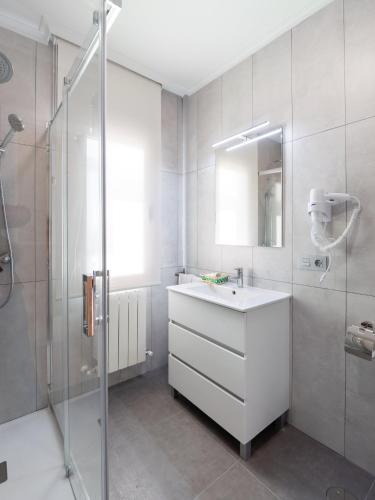 a white bathroom with a sink and a shower at Apartamento Los Castillos 2D in Tordesillas