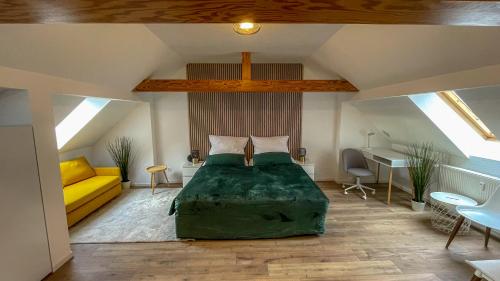 a bedroom with a large green bed in a attic at Apartment in Weißenfels bei Leuna mit WLAN & Terrasse in Weißenfels