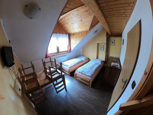 a room with two beds and chairs in a house at Penzion Na Kovárně in Branná