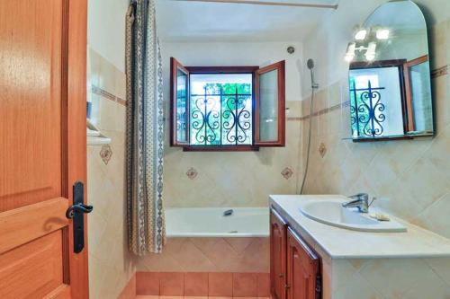 La salle de bains est pourvue d'un lavabo, d'une baignoire et d'une fenêtre. dans l'établissement LOCATIONS-06 LA PASCALINE MEUBLÉ 4**** 30MN MER, à Le Bar-sur-Loup