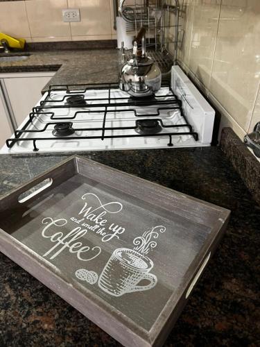 a kitchen stove with a sign with a coffee cup on it at Duplex 1 Villa Ramallo in Estación Ramallo