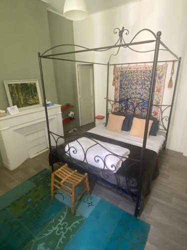 - une chambre avec un lit à baldaquin en métal et un banc dans l'établissement ® Le Musicien - T2 de charme au coeur de Marseille, à Marseille