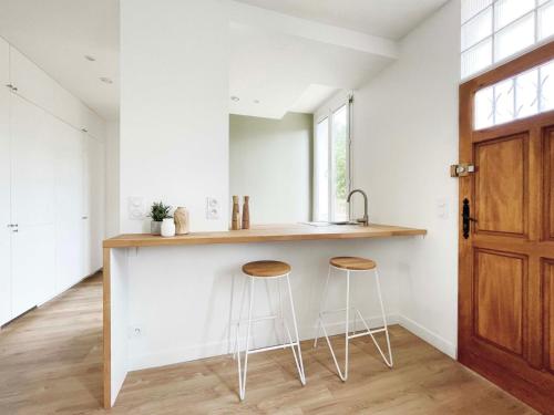 a kitchen with a counter and two stools at Ma Belle Conciergerie - Le Cocon Mélunais in Melun