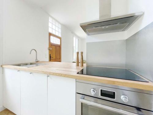 a kitchen with a sink and a stove at Ma Belle Conciergerie - Le Cocon Mélunais in Melun