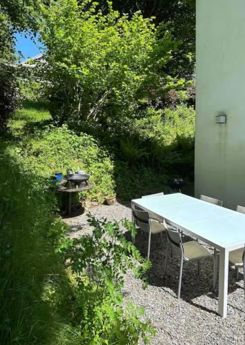a white table and chairs in a garden at Pinewood Lodge in South Brent