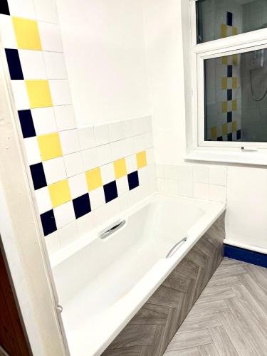 a white bath tub in a bathroom with a window at Ridley Premium Stay in Leicester