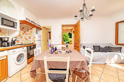 une cuisine et une salle à manger avec une table dans une pièce dans l'établissement Locations-06 La maison de Noélie 1er étage, gite pour 6 au calme sur la Côte d'Azur, à Le Bar-sur-Loup