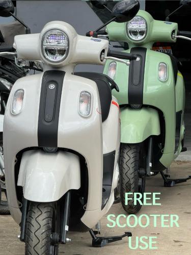 a green and white scooter parked in a parking lot at Inigtan Lio Villas in El Nido