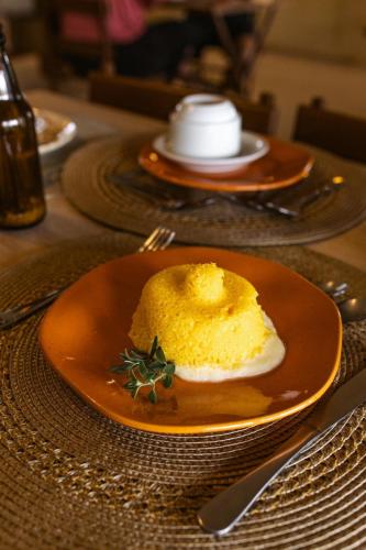 an orange plate with a yellow dessert on a table at Vila Cerrado in Alto Paraíso de Goiás