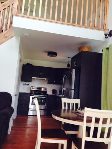 een kleine keuken met een tafel en stoelen en een trap bij Le Chalet d'Isabelle in La Conception