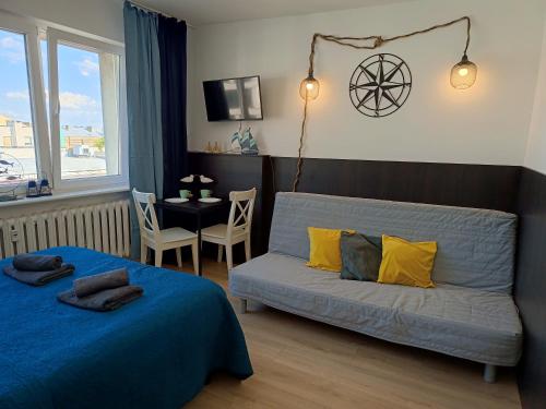 a bedroom with a bed and a couch and a table at Good Night in Szczecin in Szczecin