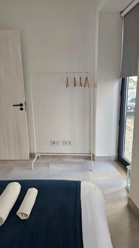 a white room with a bed and a white refrigerator at City Center Villa in Faro