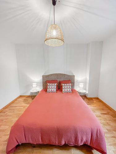 a bedroom with a large red bed with two pillows at Immersion Naturelle à Castelnaud in Castelnaud-de-Gratecambe