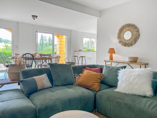 a living room with a blue couch with colorful pillows at Immersion Naturelle à Castelnaud in Castelnaud-de-Gratecambe