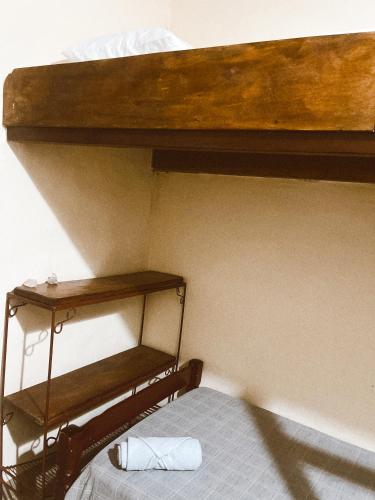 a bunk bed with two wooden shelves on the wall at Bela Oyá Casa Hostel in Vale do Capao