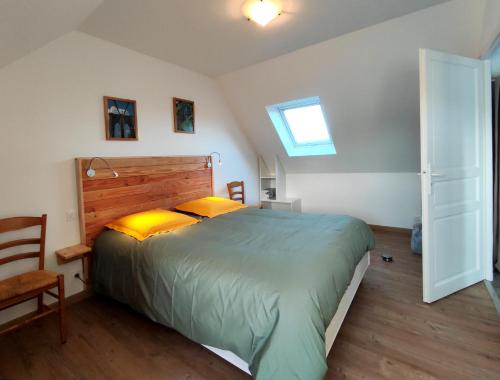 une chambre avec un grand lit et une fenêtre dans l'établissement Location bretagne Plougasnou LocPalais, à Plougasnou