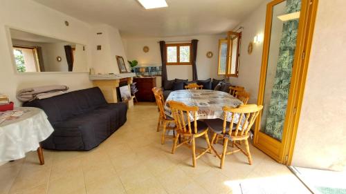 un salon avec une table et un canapé dans l'établissement Locations-06 La Maison du Paysan Villa indépendante pour 8 sur la Côte d'Azur, à Le Bar-sur-Loup
