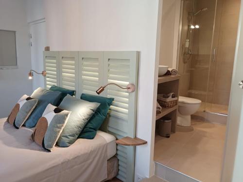 une chambre avec un lit avec des oreillers bleus et blancs dans l'établissement Centre historique studio rénové avec vue, à LʼIsle-sur-la-Sorgue