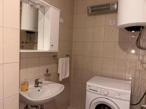 een badkamer met wastafel en wasmachine bij Apartman Vinka in Trogir