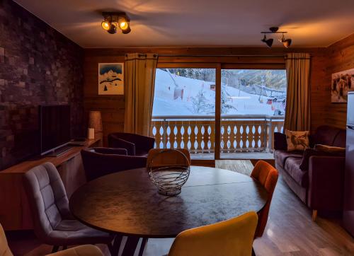 a room with a table and chairs and a ski resort at L'Étoile du Linga in Châtel