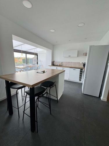 une cuisine avec une grande table et des chaises en bois dans l'établissement La bulle d'Opale, à Équihen-Plage