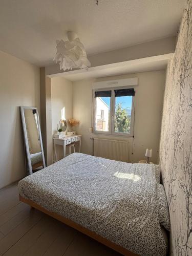 une chambre avec un lit et une fenêtre dans l'établissement Appartement proche gare avec terrasse, à Besançon