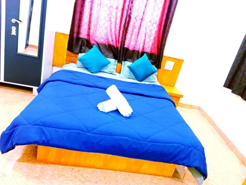 a bed with a blue comforter and blue pillows at Kavyam Villa in Mahabaleshwar