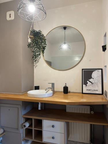 une salle de bain avec un lavabo et un miroir dans l'établissement Appartement proche gare avec terrasse, à Besançon