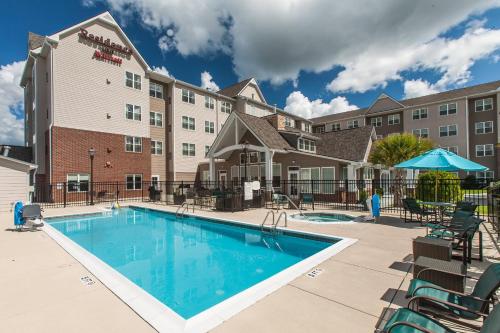 a pool at a hotel with chairs and a building at Residence Inn Florence in Florence