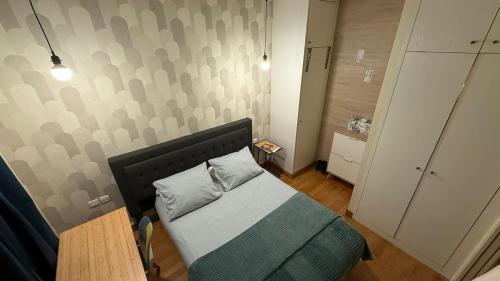 une petite chambre avec un lit et une table dans l'établissement Les balcons de Victor Hugo, à Paris