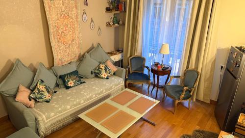 un salon avec un canapé et une table dans l'établissement Les balcons de Victor Hugo, à Paris