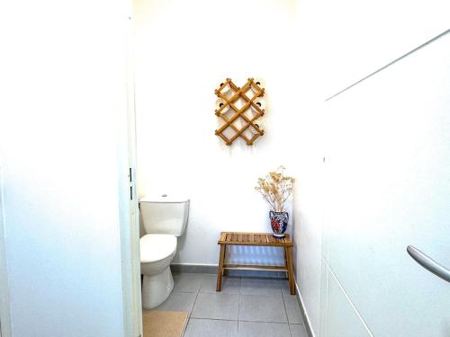 a bathroom with a toilet and a small table at Horizon Caluire - T3 chaleureux avec balcon - proche Lyon in Caluire-et-Cuire