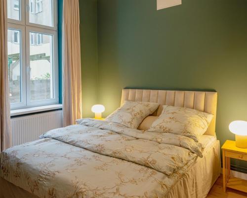 a bedroom with a bed with two lamps and a window at Modern Design Apartment in Berlin