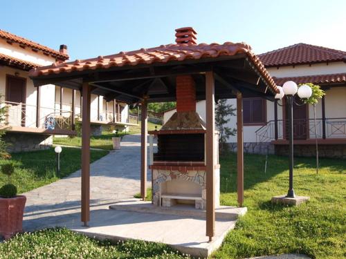 a gazebo with a bench in front of a house at Karyon Apartments in Kariófiton