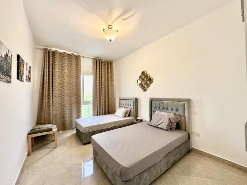 a bedroom with two beds and a window at Perfect Home Away from Home 3 BR - Maids in Ras al Khaimah