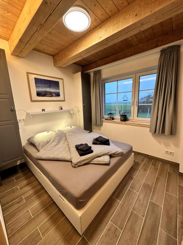 a bedroom with a large bed in a room with windows at Haus Treibsel in Dagebüll