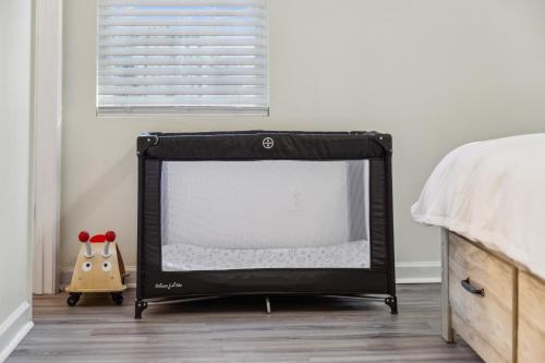 a black crib in a bedroom with a bed and a window at The Modern Recharging Station in Marietta