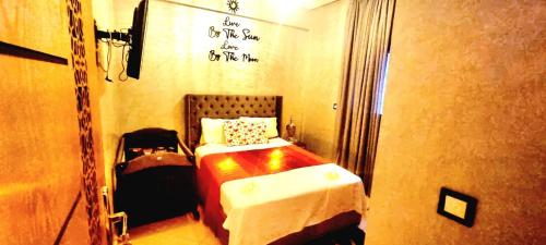 a small bedroom with a bed in a room with writing on the wall at Apprt Ennakhil 3 in El Jadida