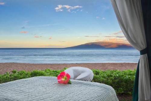 a table with a flower on the beach at Marriott's Maui Ocean Club - Lahaina & Napili Towers in Lahaina