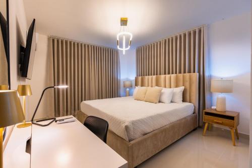 a hotel room with a bed and a desk with a table sidx sidx at Modern 3BR! 9fl, King Bed! Sti!, in Santiago de los Caballeros