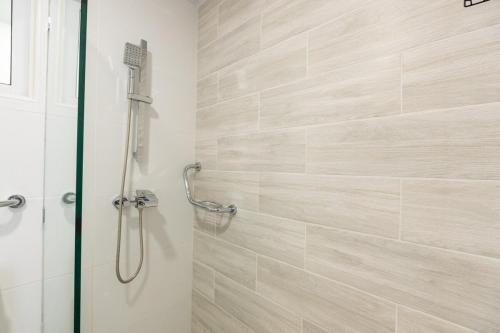 a bathroom with a shower with a glass door at Modern 3BR! 9fl, King Bed! Sti!, in Santiago de los Caballeros
