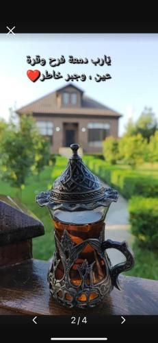 a vase sitting on a table in front of a house at Villa Lux in Quba in Quba