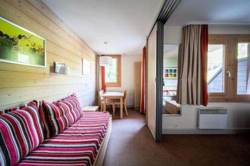 un salon avec un canapé et une table dans l'établissement Résidence Plagne Lauze - maeva Home - Studio 4 personnes - Budget MAE-8134, à Mâcot La Plagne
