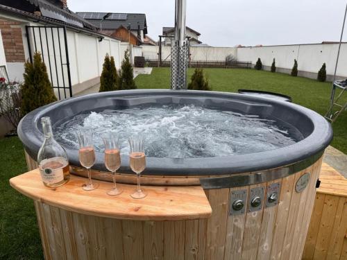 a hot tub with wine glasses and wine bottles at Casa Valentina in Cristian