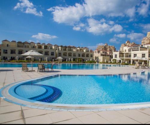 a pool at a resort with buildings in the background at Perfect Home Away from Home 3 BR - Maids in Ras al Khaimah