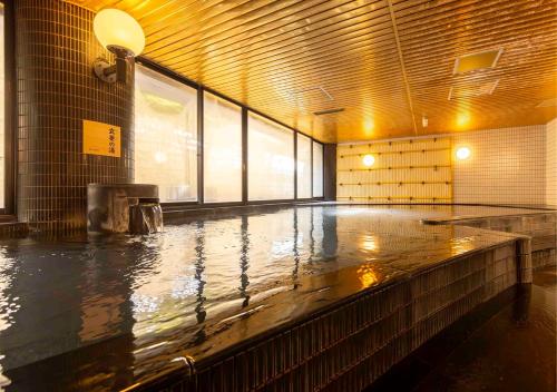 a large pool of water in a room with a large window at APA Hotel Kanazawa Ekimae in Kanazawa