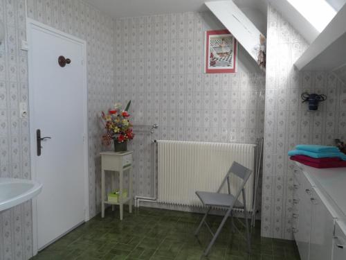 a bathroom with a chair and a sink at Le Franquevillette in Boos
