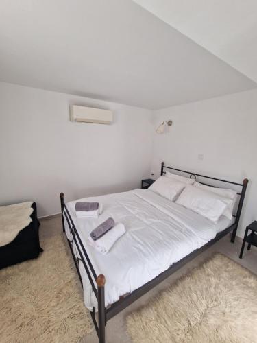 a bedroom with a bed with white sheets and towels at ΔΙΑΜΕΡΙΣΜΑ 45τμ ΕΛΕΟΥΣΑ ΙΩΑΝΝΙΝΑ in Eleoúsa