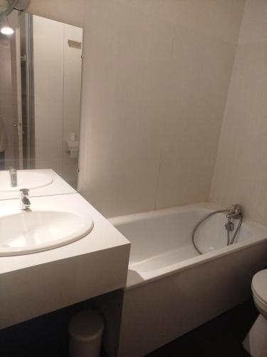 une salle de bain avec un lavabo et une baignoire dans l'établissement Résidence Le Tourmalet - maeva Home - Studio 5 personnes - Confort MAE-8581, à La Mongie