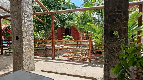 a wooden gate leading into a garden with a house at Casa de hóspedes Balibar Cumbuco in Cumbuco